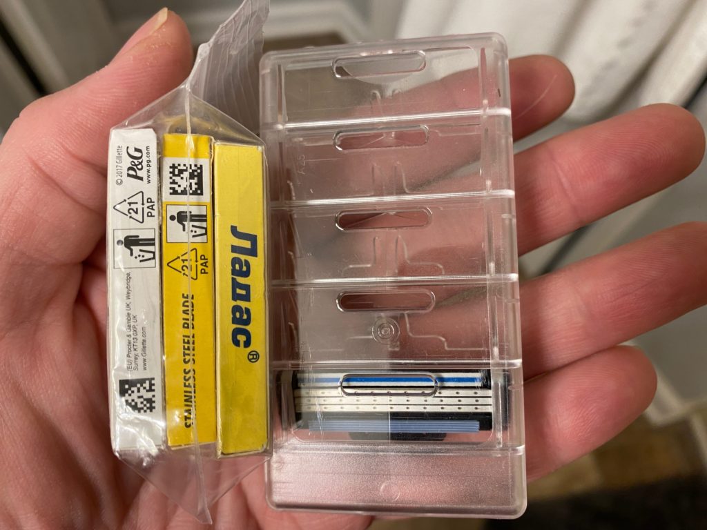 A photo of three boxes of razor blades alongside a 5-cartridge case.