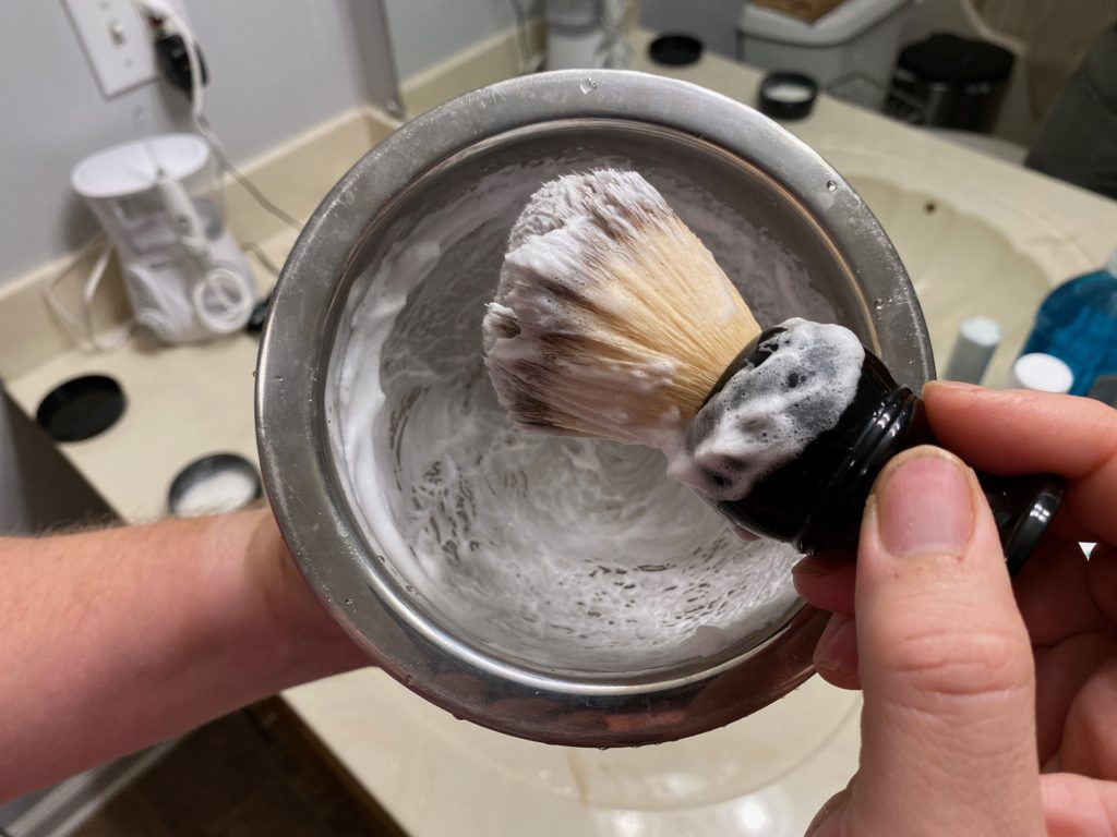A photo of a shave brush with lathered shave soap
