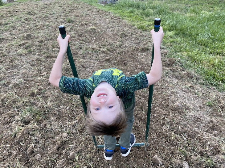Child leaning back on broadfork