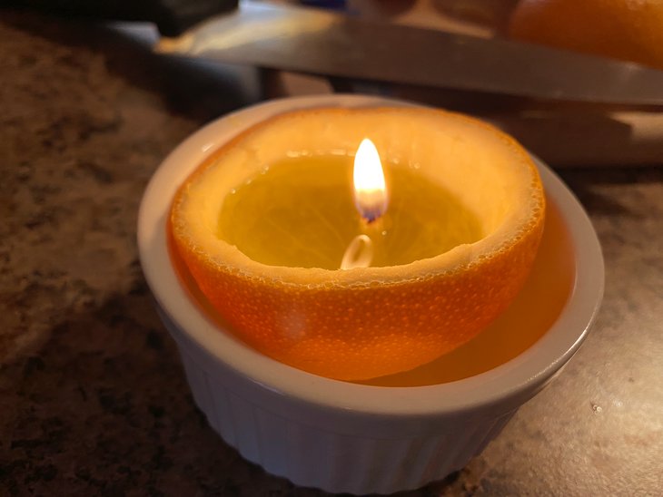 An orange candle in a ramekin