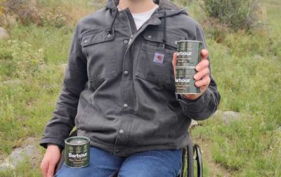 Man in a wheelchair holding cans of wax
